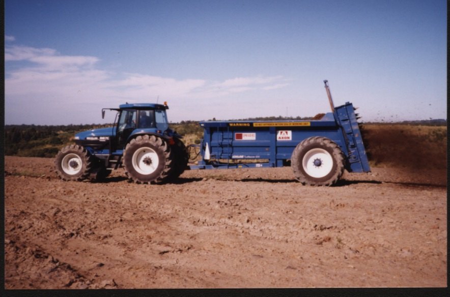 Tractor and spreader applying biosolids to agricultural land